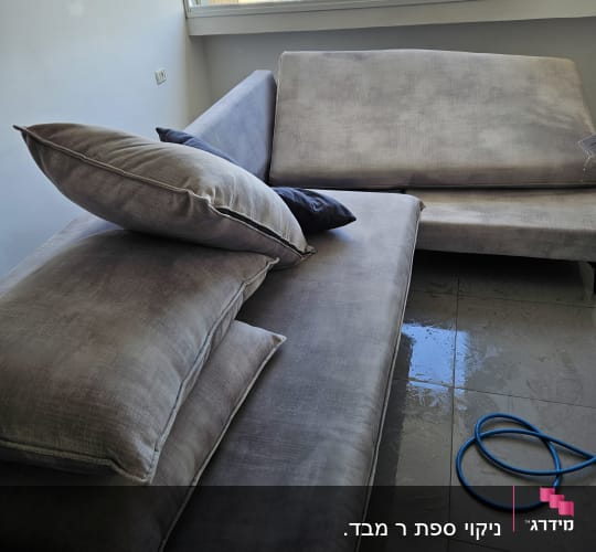 ספה עם כריות, רצפה רטובה וצינור כחול